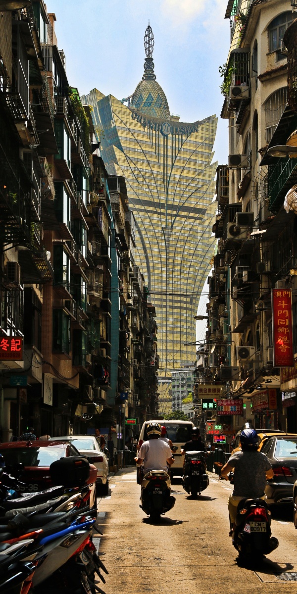 新旧交融传统的澳门居民楼夹着金色的澳门新葡京陈旧的砖瓦映衬着现代
