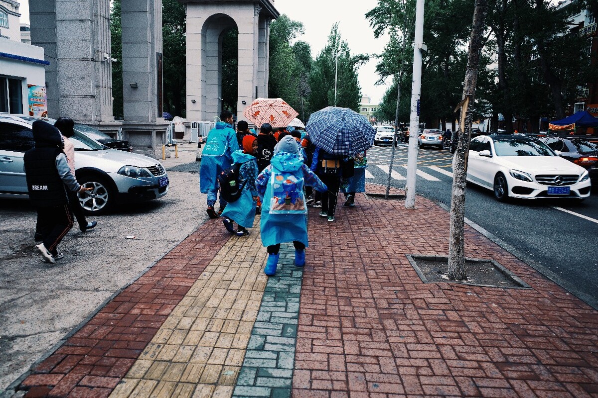 街拍雨中放学后的小学生们,我们都曾是少年.