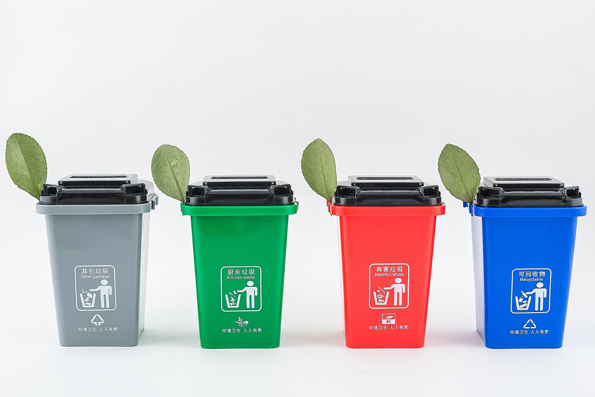 白背景上摆放的用作不同垃圾分类用途的垃圾桶,保护环境主题图片.