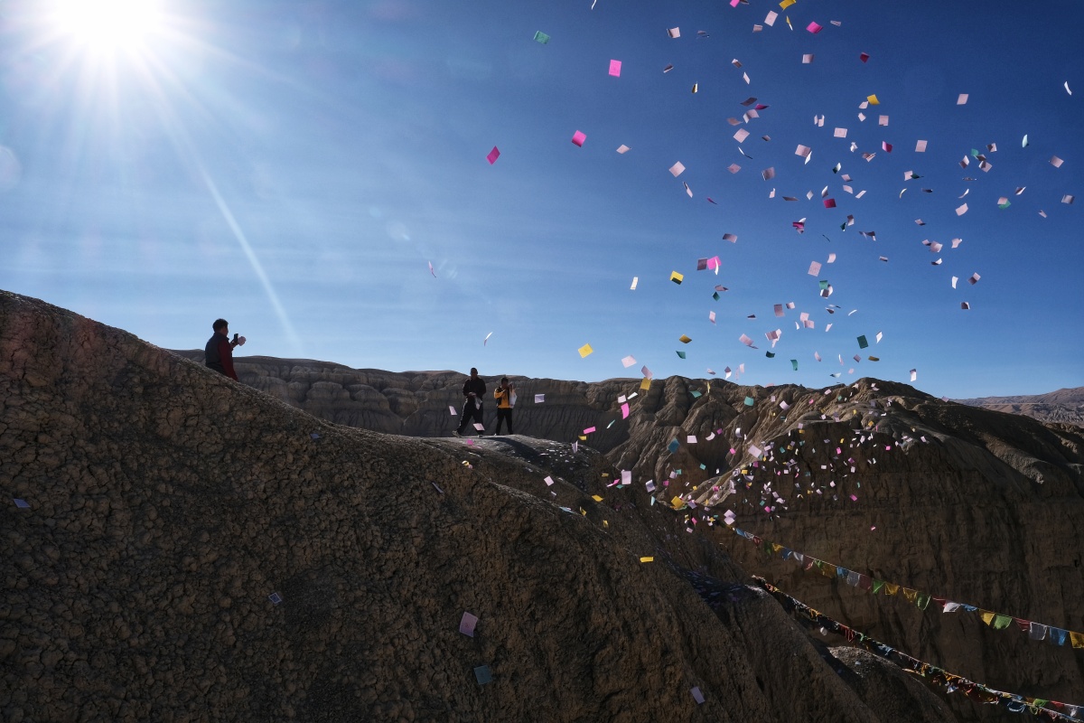 抛撒风马旗的人阿里札达古格遗址山顶