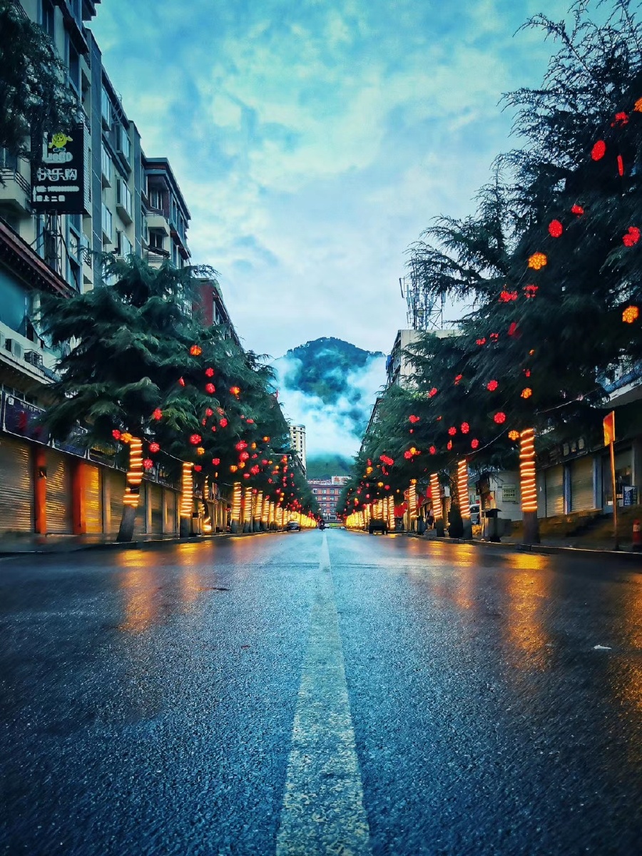 四川省甘孜州九龙县城清晨街道薄雾雪山