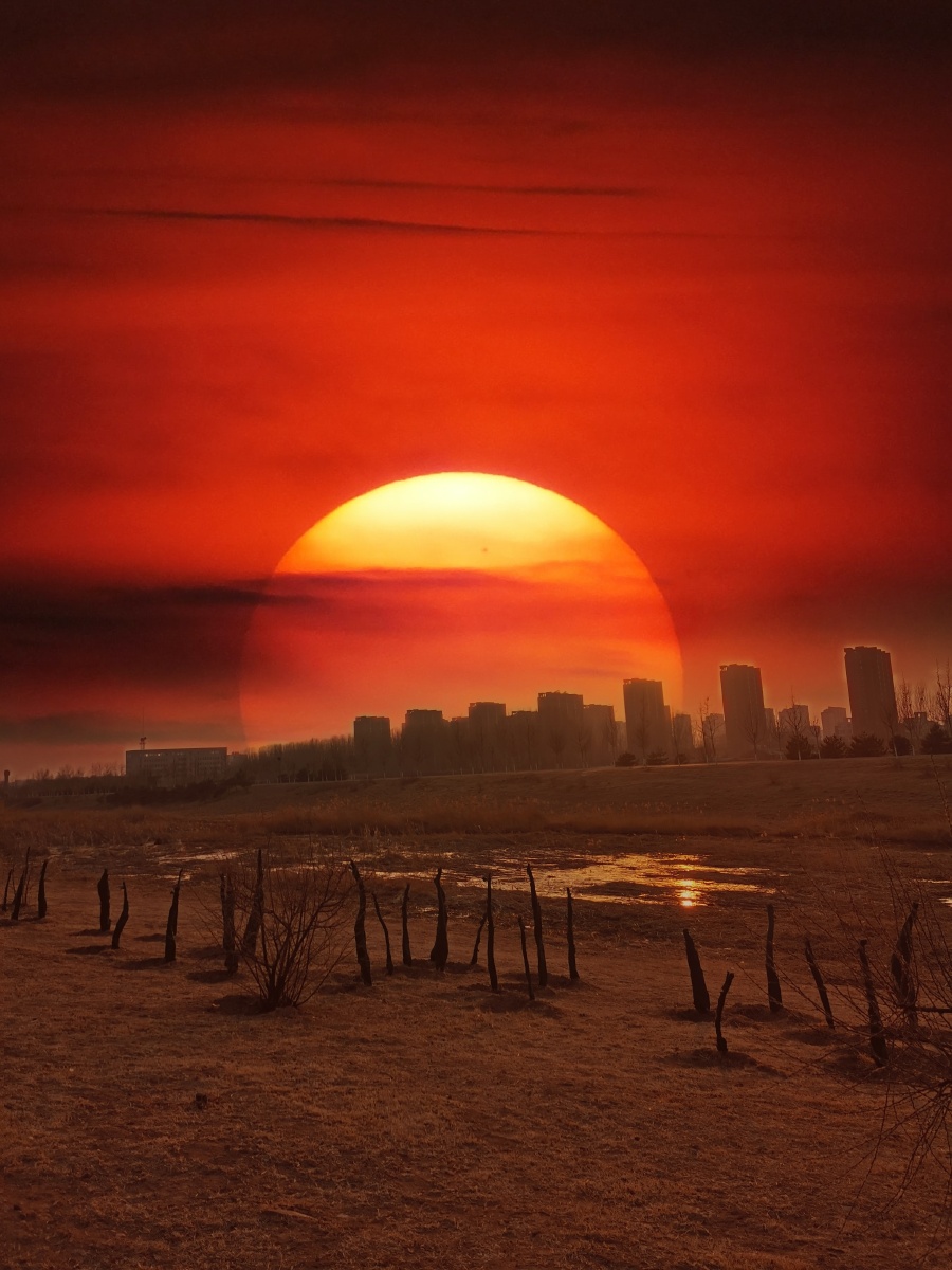 夕阳西下落日余晖映衬了钓鱼爱好者的执着一根鱼竿一把小椅子一条弯曲