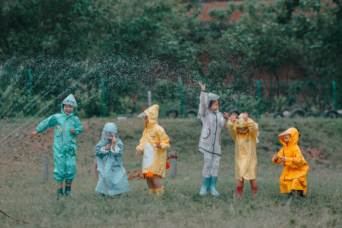 这两天天气不好下起了雨小朋友们索性穿上雨衣出去玩嫌雨不够大还要
