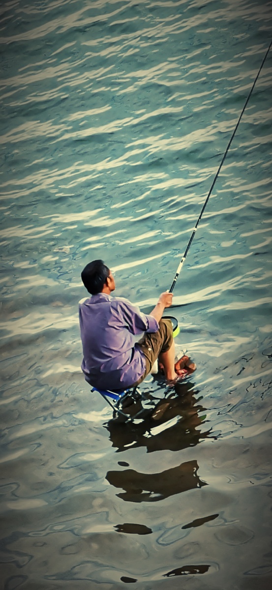 江边水中垂钓者