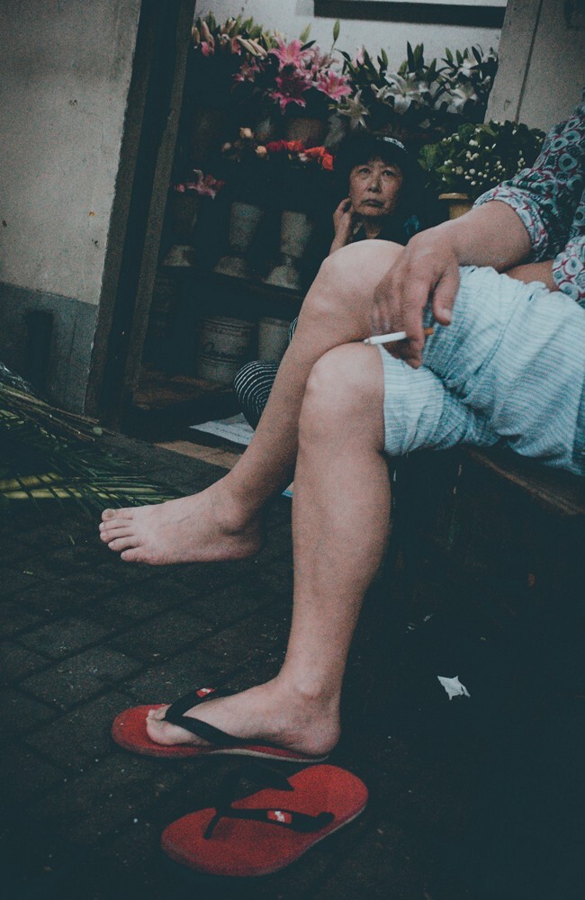 路过一个花店，玻璃门里的女士正在一动不动地注视着外面坐着的那个男人。