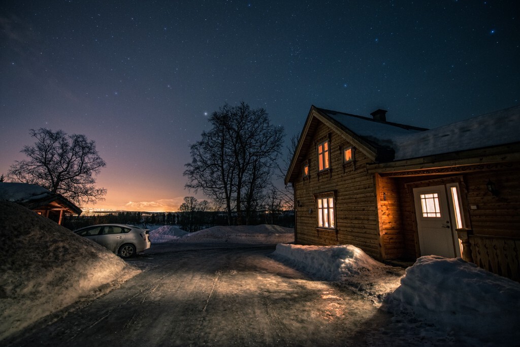 这里是北极。在冰天雪地的夜晚，还有什么比小木屋窗户里透出的一丝暖光更温馨呢？