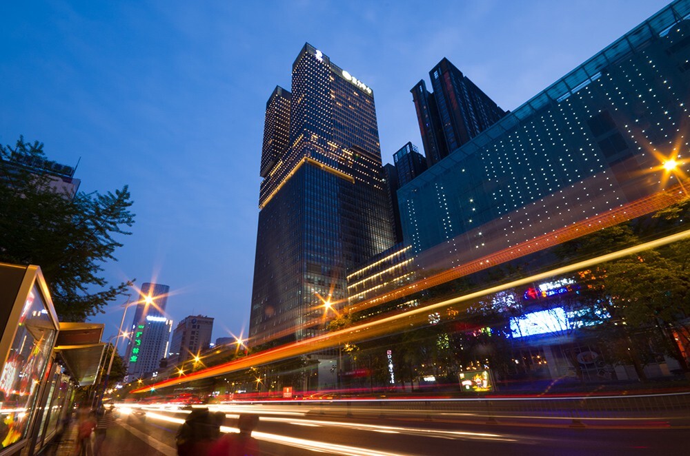 夜幕下的城市街道，这只头正好装下高耸的楼房，公交车站前车来车往，慢门的表现可圈可点。