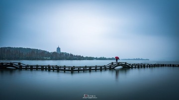 西湖雨又风，雨伞是媒红
