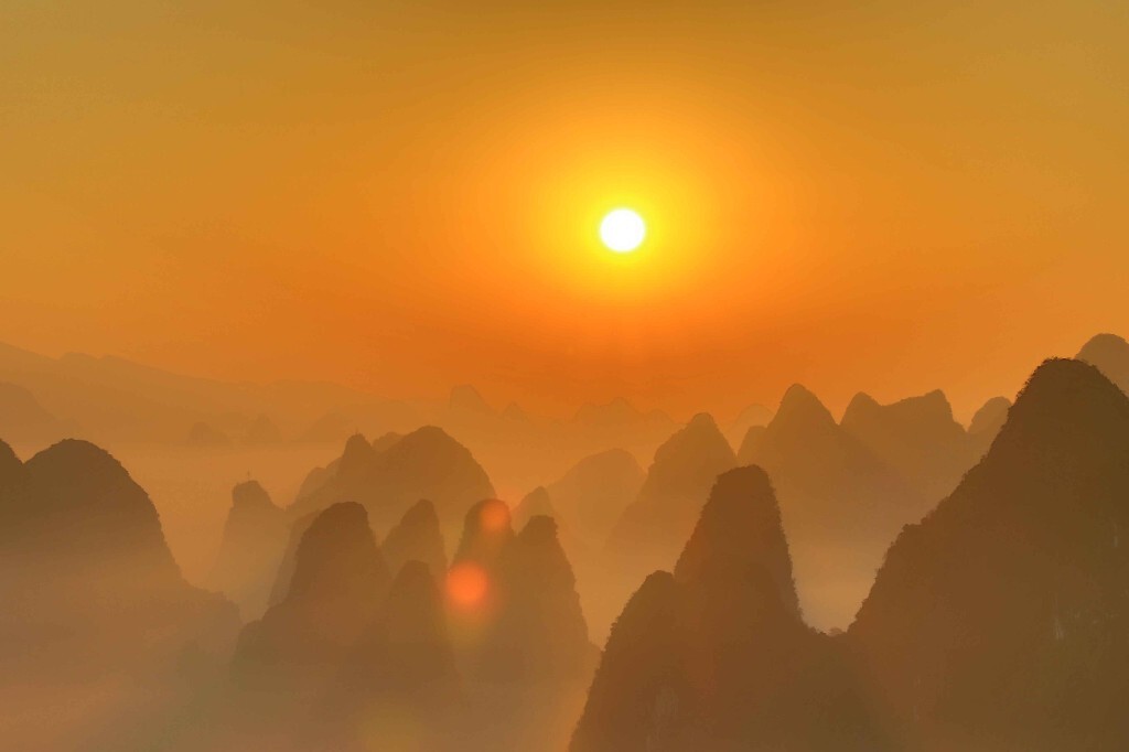 7点37分，太阳升至半空中，一道迷人的炫光斜射入镜头，依旧缭绕的云雾被染成了黄色，像是层金粉，群峰则青得发黑。整幅由黑、金色构成的画面像是神话中创世的场景，神秘而可畏。“在远古，我们的祖先此刻会不会对着太阳长拜不起呢？世上文明的元叙事是不是皆从此开始的呢？”